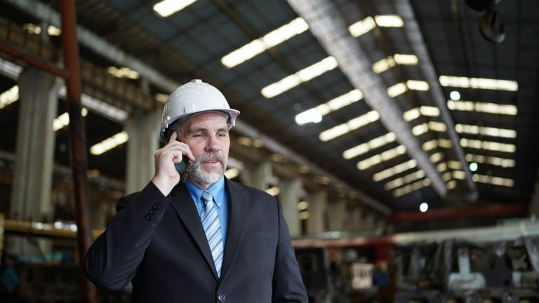 Chef einer Baufirma auf Mallorca, der mit einem Mobiltelefon über den Abschluss der Bauversicherung spricht