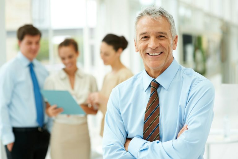 Erfolgreicher Unternehmer im Büro freut sich über Schutz der Geschäftsversicherung