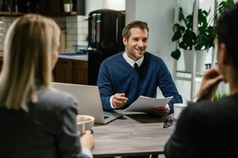 Glücklicher Versicherungsvertreter bei einem Treffen mit einem Paar auf Mallorca